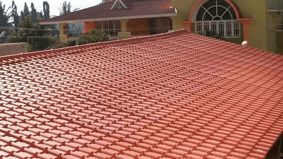 Red uPVC roofing sheets on a residential building, showcasing the textured tile-like appearance and durability. Learn about the advantages and disadvantages of uPVC roofing for your home.