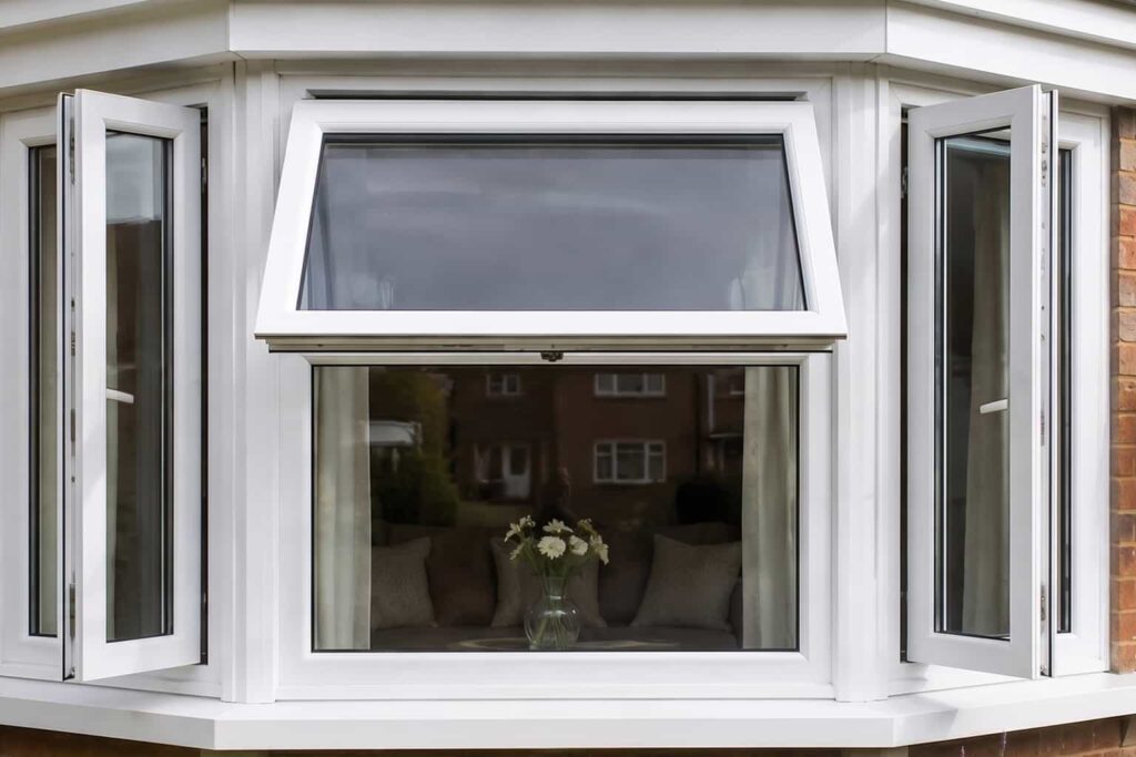 UK red-brick house with white uPVC bay window and outward-opening casement windows